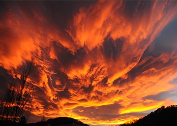 Blick in den Himmel, dessen Wolken rot gefärbt sind